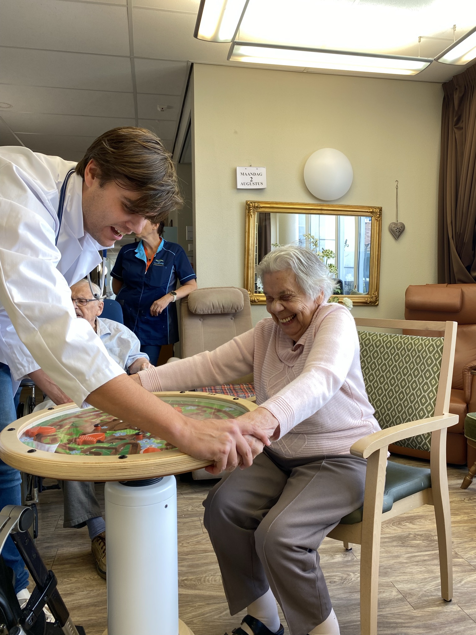 Eldercare professional helps elderly woman play with ISC Swinging top maze