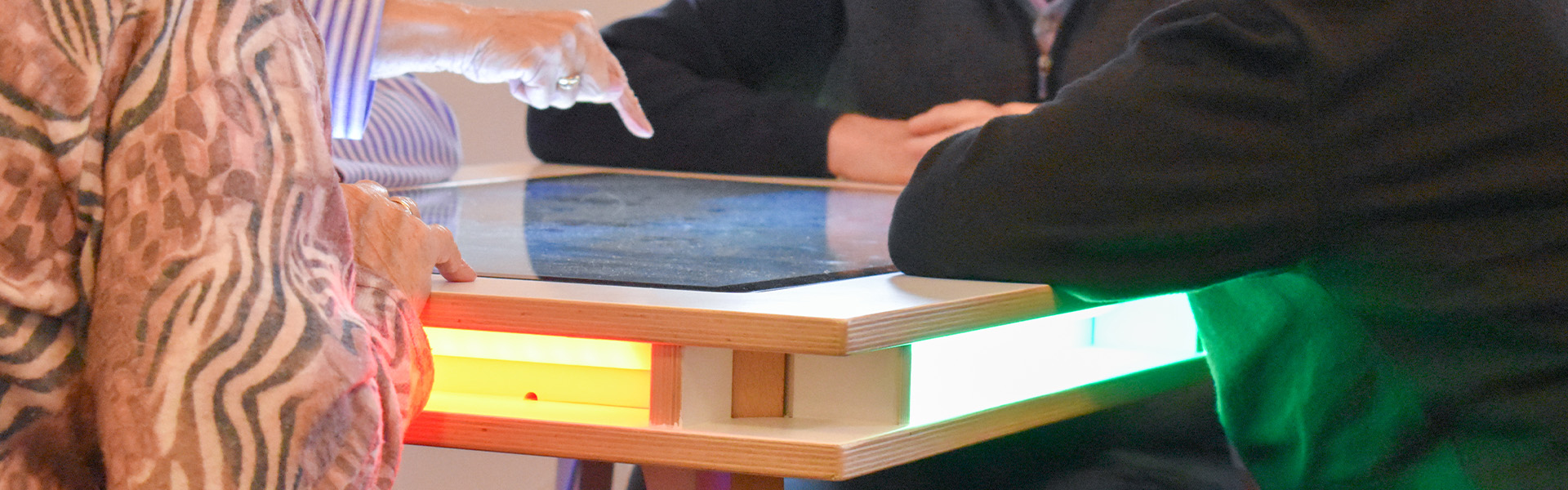 Las personas mayores juegan con una mesa de juego interactiva Las personas mayores juegan con una mesa de juego interactiva