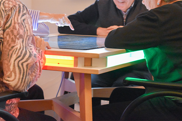 Seniors play with interactive table in retirement home