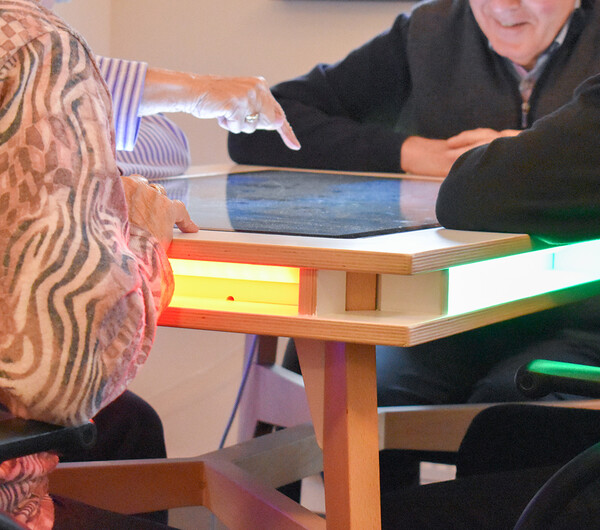Elderly people play games at interactive gaming table